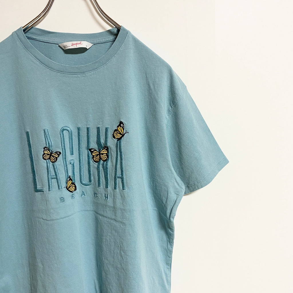 半袖ロゴ刺繍Tシャツ　クルーネック　蝶　バタフライ　ラグナビーチ　水色　ライトブルー　春夏服　Mサイズ　古着